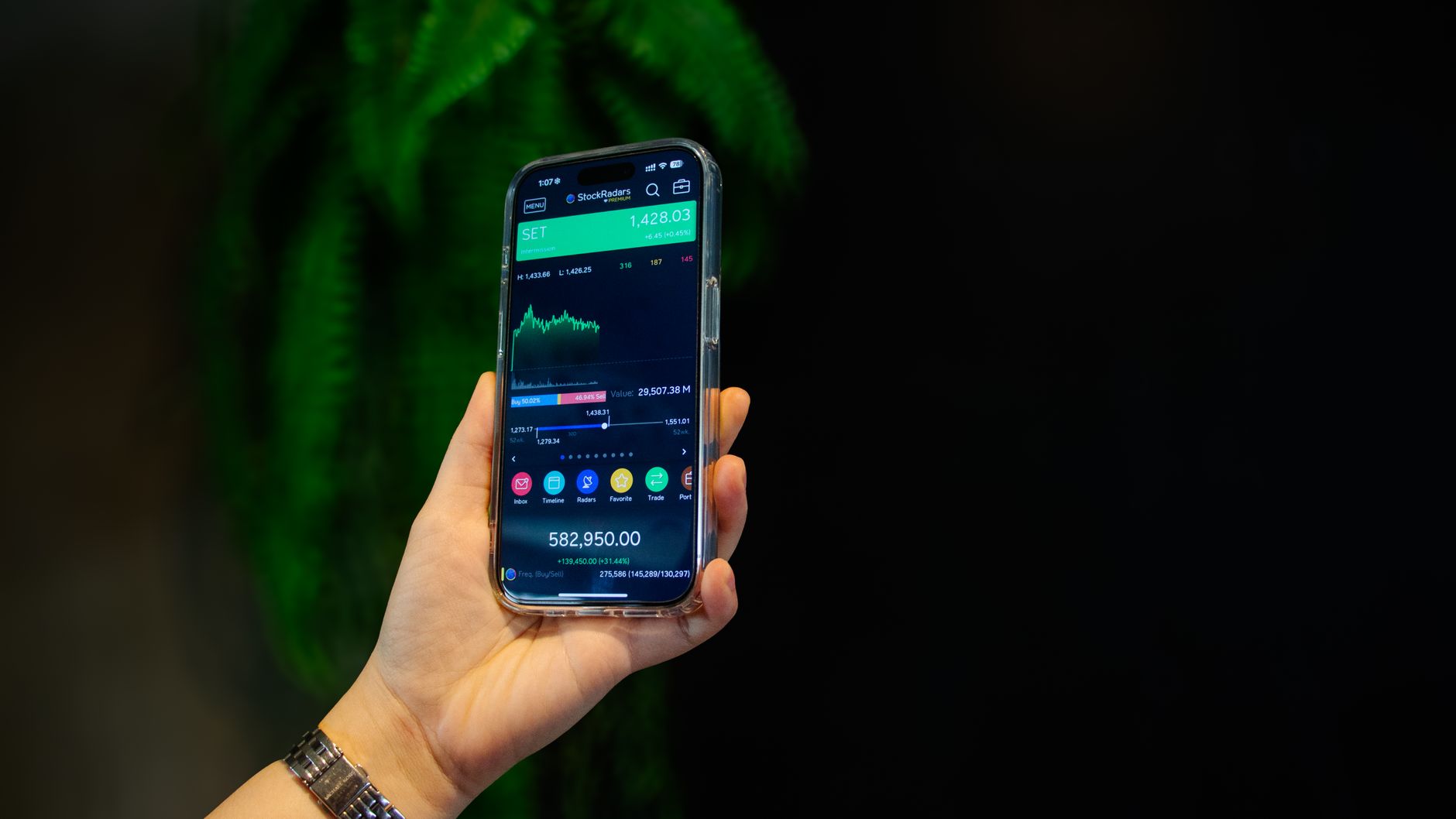 Close-up of a smartphone displaying a stock trading app with market data on-screen.