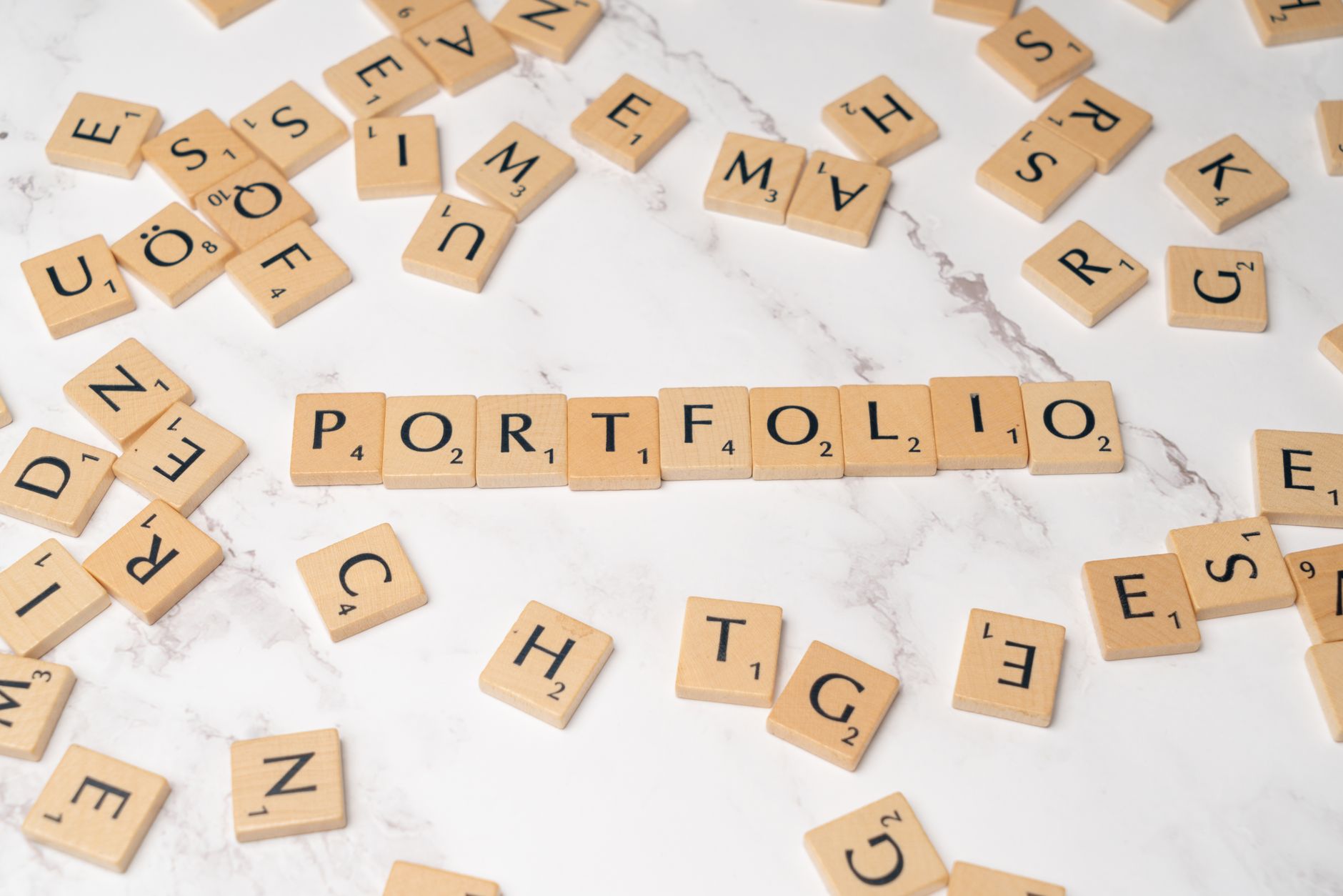 Scrabble tiles spelling 'PORTFOLIO' on a marble surface. Perfect for business and creativity themes.