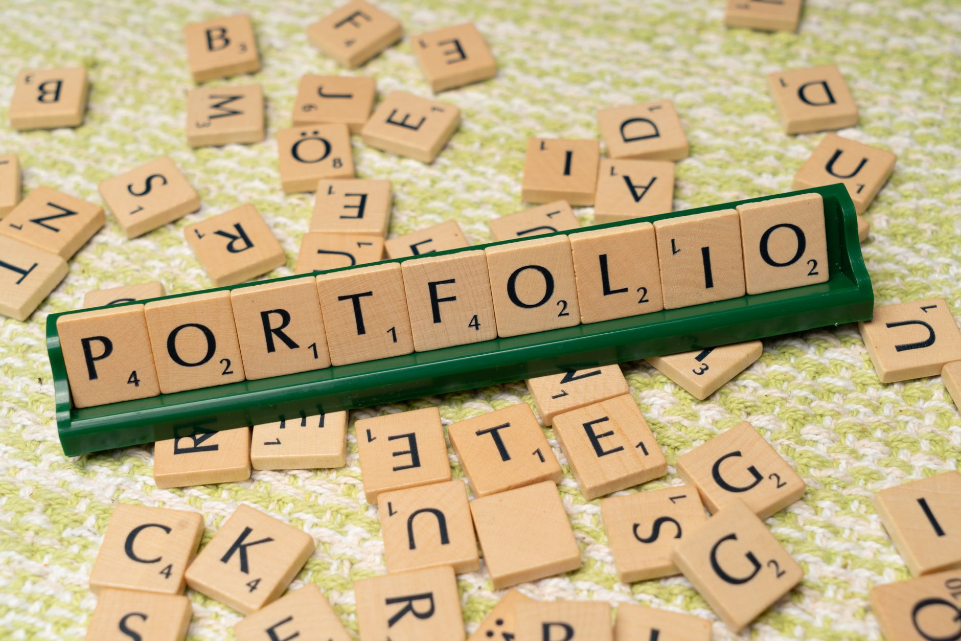 Wooden Scrabble tiles spelling 'PORTFOLIO', perfect for creative and educational themes.