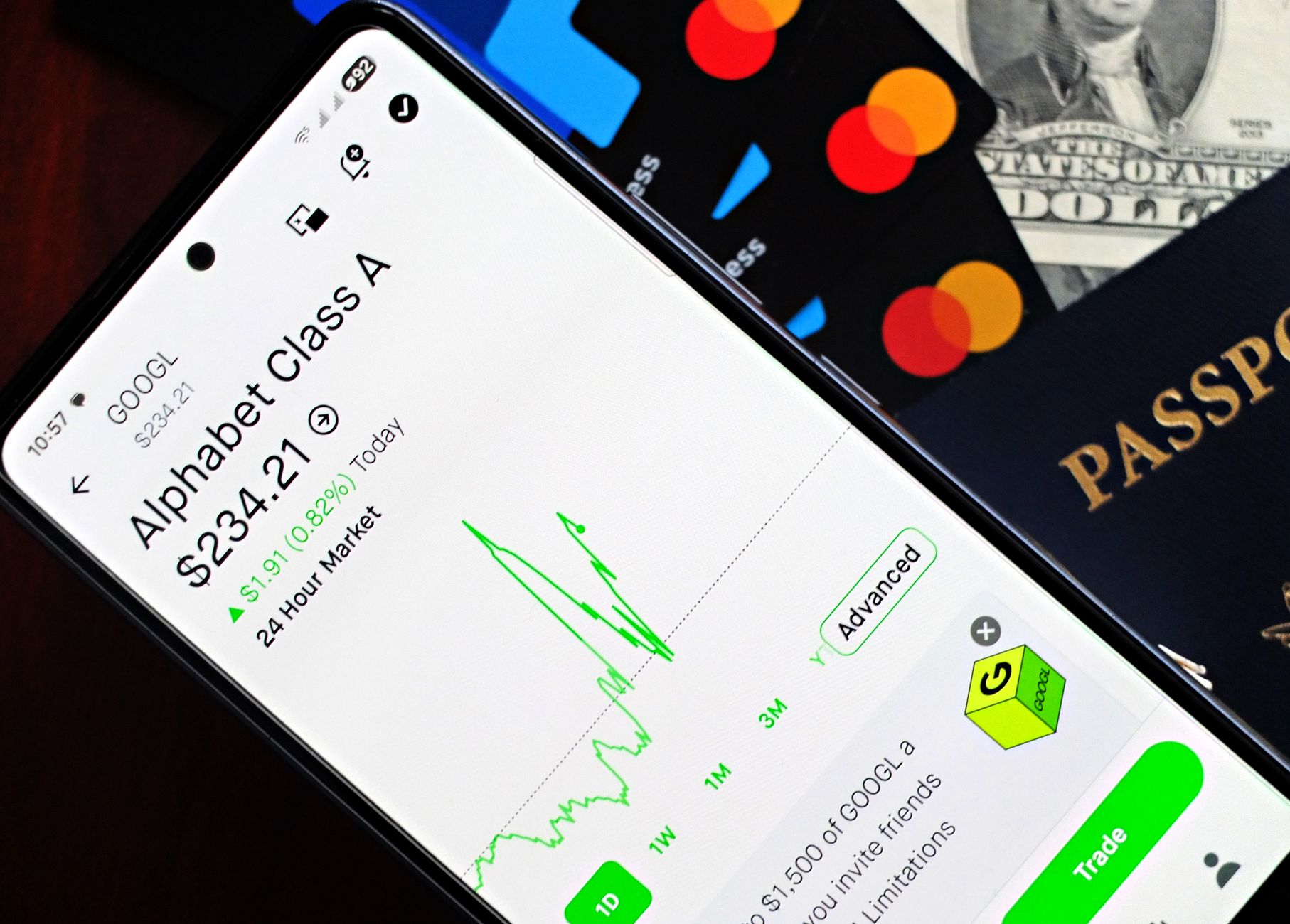 Smartphone displaying stock market app next to U.S. dollar and passport, representing global finance.